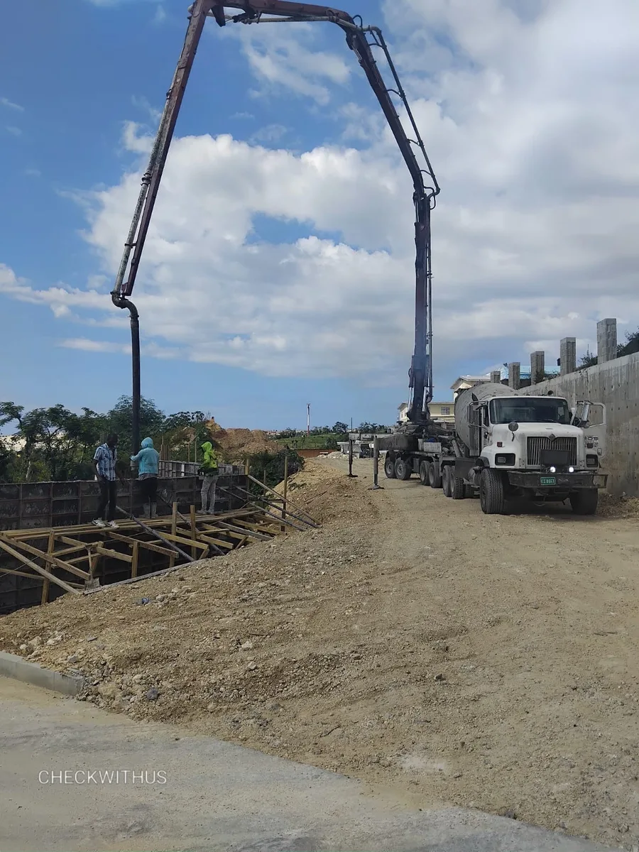 Check With Us concrete pump truck on site in Jamaica